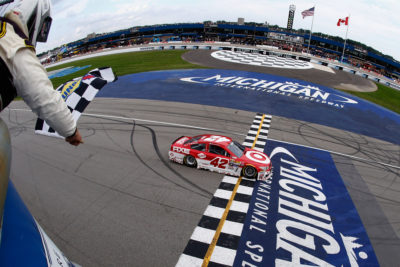 BROOKLYN, MI - AUGUST 28: Kyle Larson, driver of the #42 Target Chevrolet, takes the checkered flag to win the NASCAR Sprint Cup Series Pure Michigan 400 at Michigan International Speedway on August 28, 2016 in Brooklyn, Michigan. (Photo by Jeff Zelevansky/NASCAR via Getty Images)